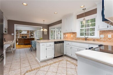 Kitchen with Corian countertops, ceramic tile floors, tile backsplash and nice and bright!
