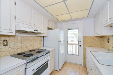 White cabinets and countertops in kitchen with a s