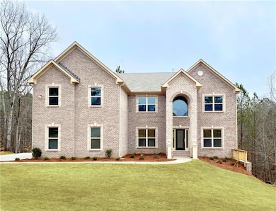 View of front of home with a front lawn and brick 