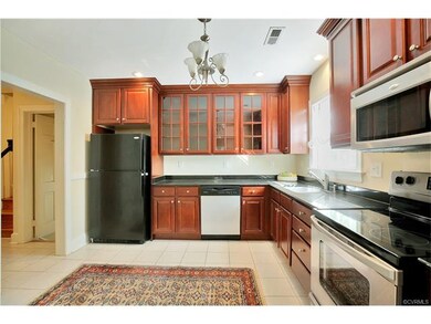 Granite counters, cherry cabinets, stainless and black appliances.  Tiled floor, eat-in area.