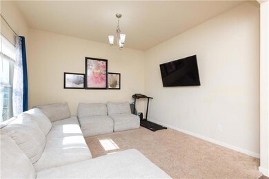 Carpeted living room with an inviting chandelier a