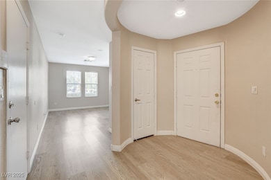 Foyer entrance with light wood-type flooring and b