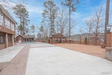 View of patio / terrace featuring a gazebo, driveway, and an outdoor structure