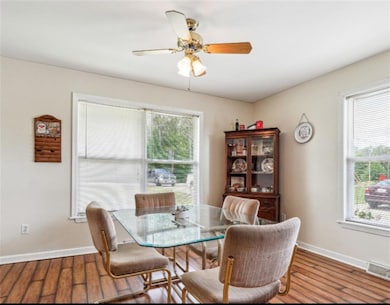 Dining space with baseboards, wood finished floors, and ceiling fan
