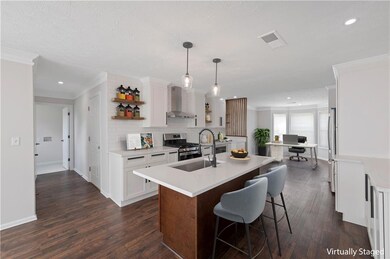 Kitchen with open shelves, light countertops, dark wood-type flooring, white cabinetry, and crown molding