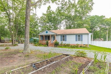 Ranch-style home featuring covered porch and a gar