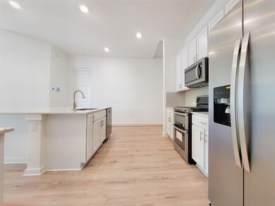 Kitchen with stainless steel appliances, light wo