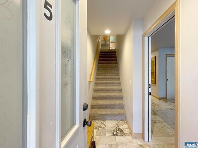 Stairs up to kitchen/living room. Door on right to