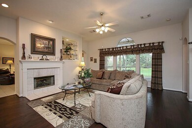 Living Room with fireplace. The glass shelves are open to both the living room and den area.
