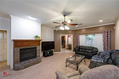 Living room with crown molding and a brick gas log