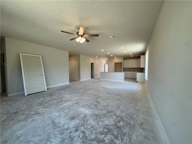 Unfurnished living room featuring a ceiling fan, r