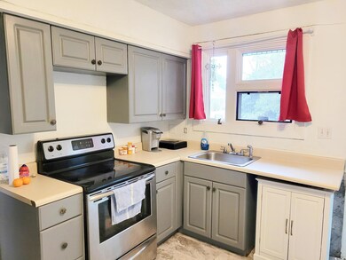 Kitchen with gray cabinetry, electric stove, and s