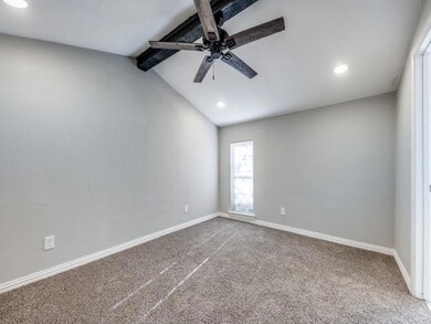 Carpeted empty room featuring ceiling fan and vaul