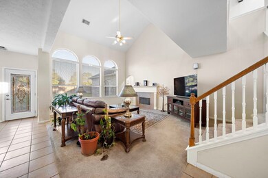 Vaulted ceiling lounge with large windows, staircase, and entertainment center.