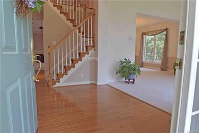 Elegant entry foyer with hardwood floors and two-s