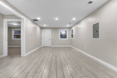 Empty room featuring wood tiled floors, recessed lighting, and electric panel