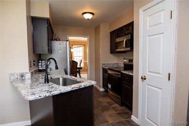 Kitchen with granite, ceramic tile floor and stainless steel appliances.