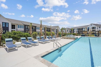 View of swimming pool featuring a community hot tu