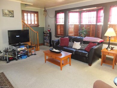 Living room has crown molding, arched doorways, a 