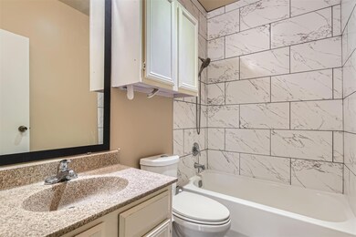 Bathroom featuring toilet, vanity, and bathing tu