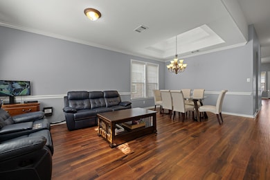Living room featuring a chandelier, a tray ceilin