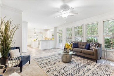 Living room with a ceiling fan, baseboards, crown 