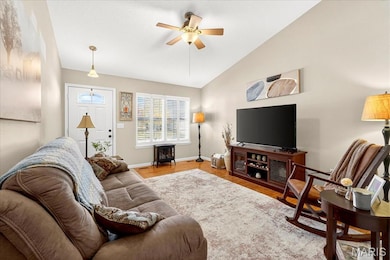 Living area featuring wood finished floors, a ceiling fan, and lofted ceiling
