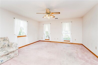 Living Room with lots of windows and a ceiling fan