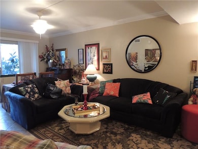 Living/dining room with tile floors, crown molding, neutral painted walls.