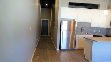 Kitchen with sink, white cabinetry, stainless stee