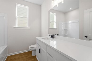 Full bathroom with wood-type flooring, shower / washtub combination, vanity, and toilet