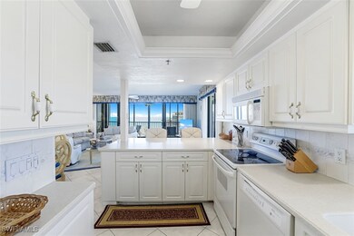 Kitchen with white appliances, a peninsula, a rais