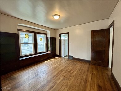 Unfurnished bedroom with white fridge and hardwood / wood-style flooring