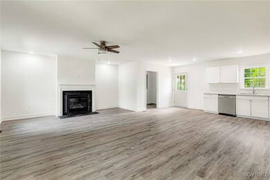 Unfurnished living room featuring a sink, light wo