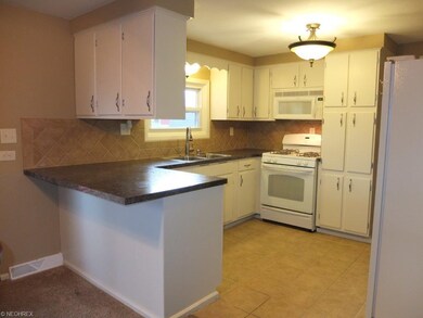 Kitchen has breakfast bar, tile flooring and backs