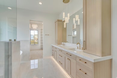 Bathroom with double vanity, a soaking tub, recessed lighting, light tile patterned floors, and a chandelier