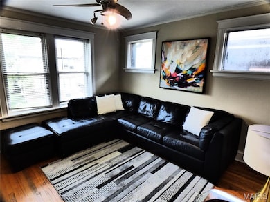 Living area with ornamental molding, plenty of natural light, hardwood / wood-style flooring, and ceiling fan