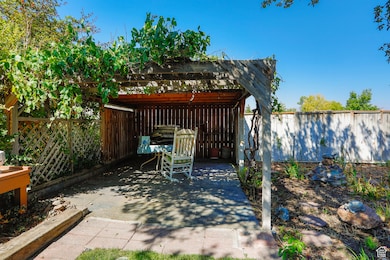Fenced backyard with a pergola and a patio