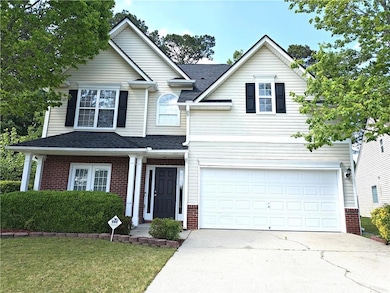 Traditional home with a garage, driveway, roof wit