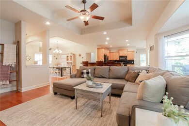 Open concept with family room featuring a tray ceiling and gas fireplace.