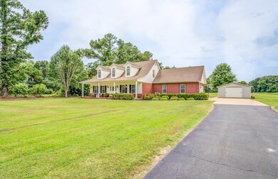 New england style home featuring a garage, an outb