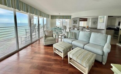 Living room with a chandelier, wood finished floors, and a water view