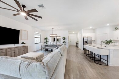 Living area with baseboards, visible vents, a ceil