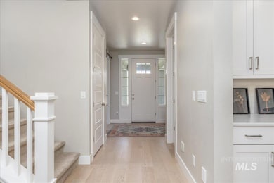 Foyer entrance with light wood-type flooring, recessed lighting, and stairway