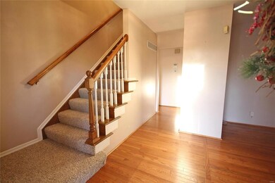 Enter to wood floors and traditional staircase.