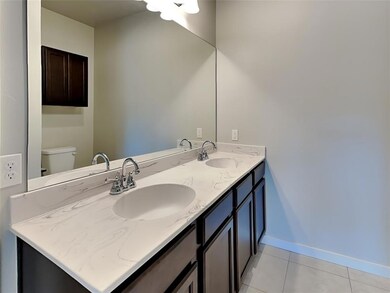 Bathroom featuring dual bowl vanity, toilet, and t