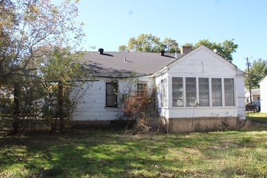 Back of property featuring a sunroom, a yard, and a chimney