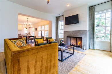 Living room with a premium fireplace, light wood-type flooring, and an inviting chandelier