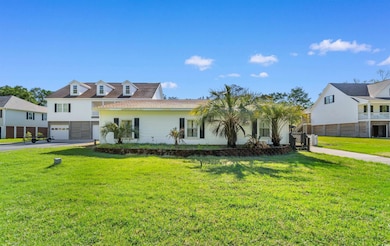 View of front of home with a front yard, a garage,