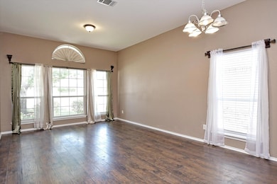 Unfurnished room featuring a chandelier, dark woo